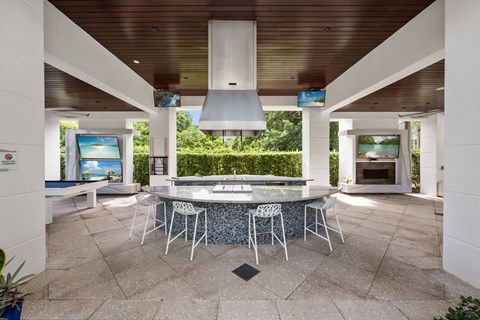 the kitchen has a large island with stainless steel appliances and a fireplace