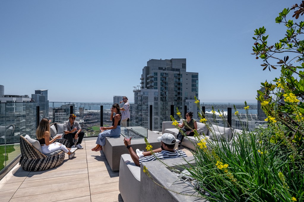 a group of people sitting on benches on a roof top