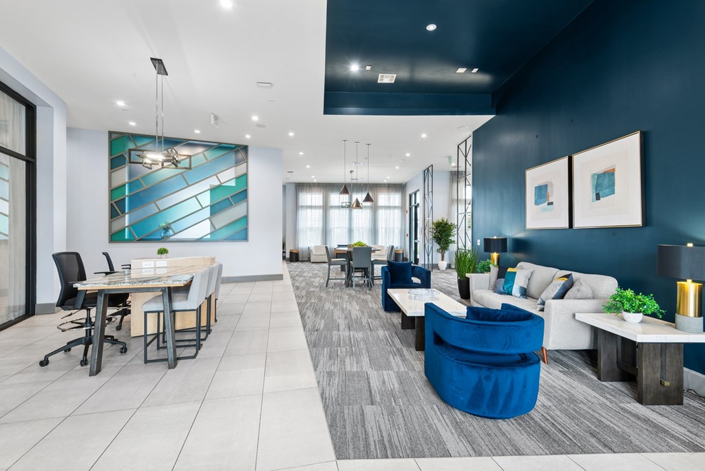A modern office space with a blue accent wall and a variety of seating options.
