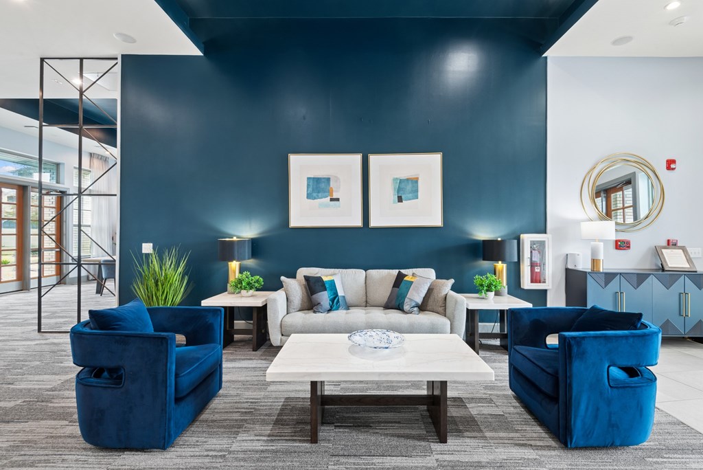 A living room with a white sofa and blue chairs.