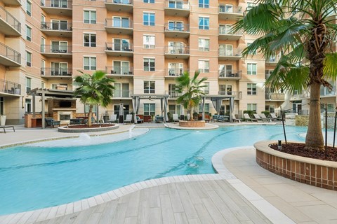 A large swimming pool in front of apartment buildings.