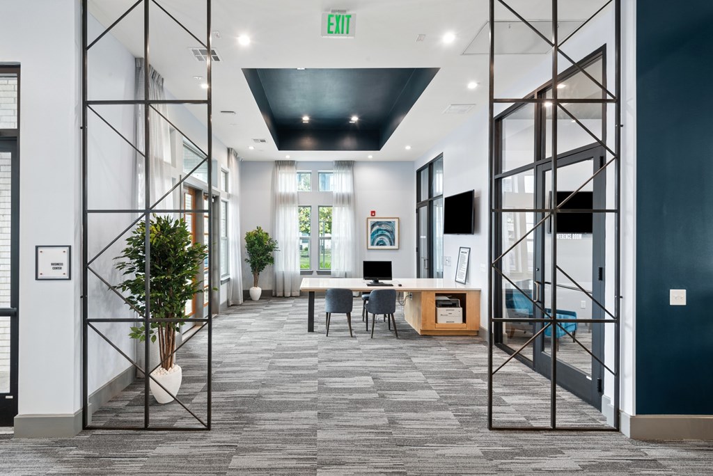 A hallway with a green exit sign above the door.