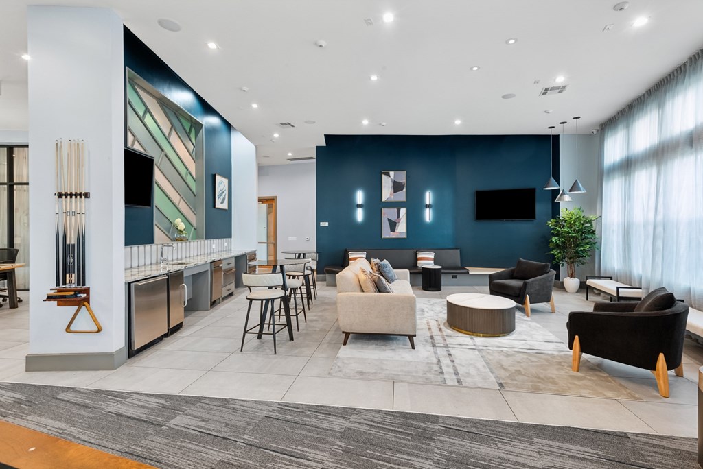 A modern living room with a kitchen area in the background.