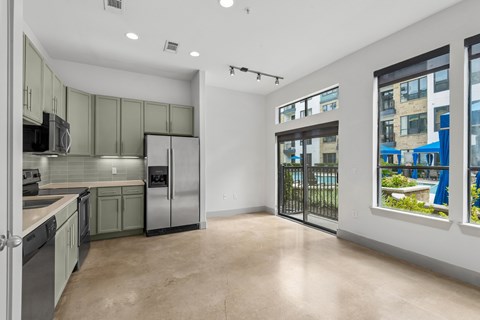 A kitchen with green cabinets and stainless steel appliances.