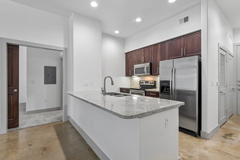 A modern kitchen with a large island and stainless steel appliances.