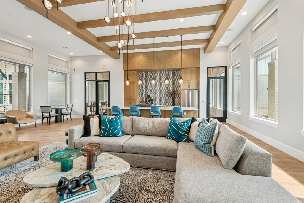 A living room with a grey couch and a wooden ceiling.