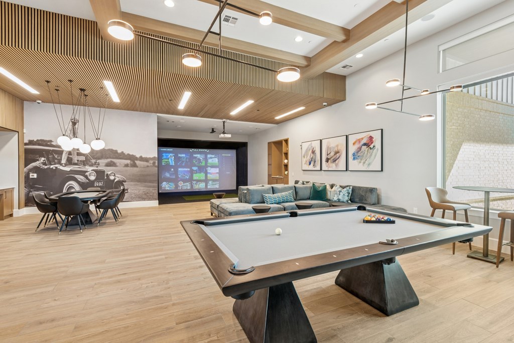 A billiard table is in the middle of a room with a TV and a couch.