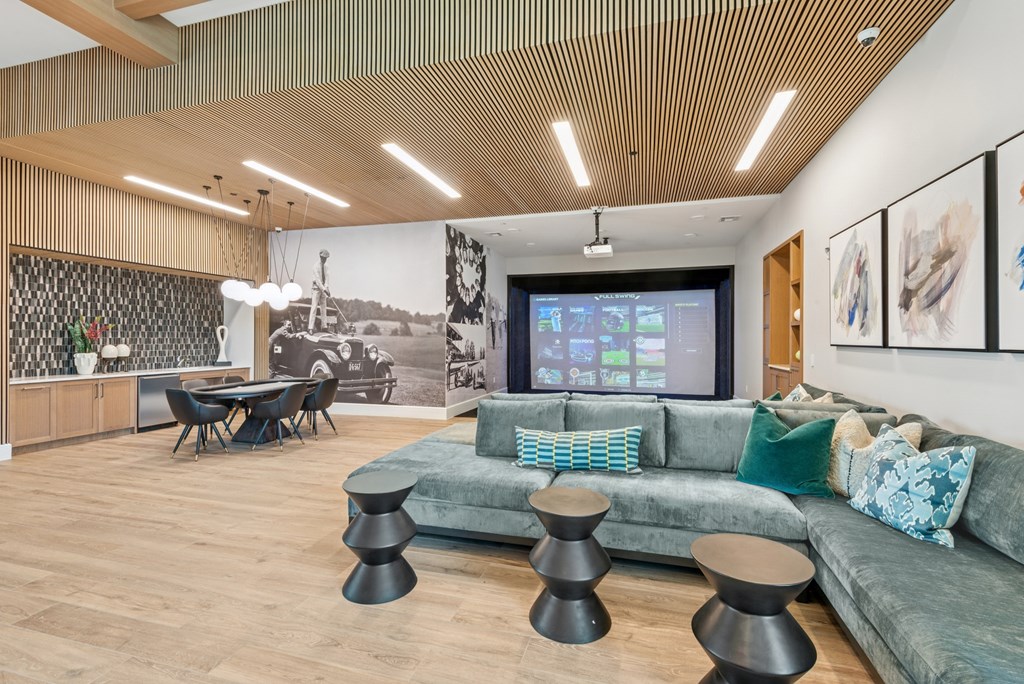 A living room with a green couch and a wooden floor.