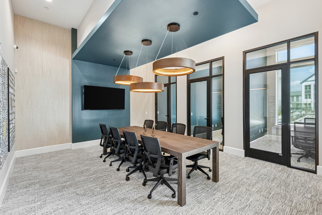A conference room with a long table and chairs.