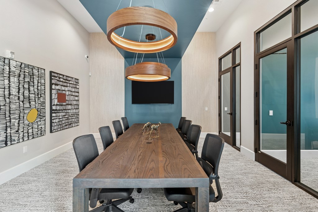 A conference room with a long table and chairs.