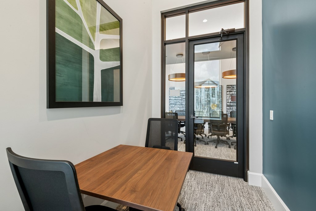 A conference room with a wooden table and chairs.