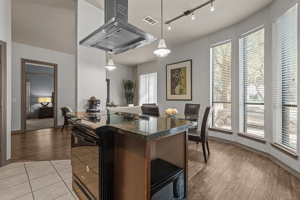 a kitchen with a large island and a dining table with chairs