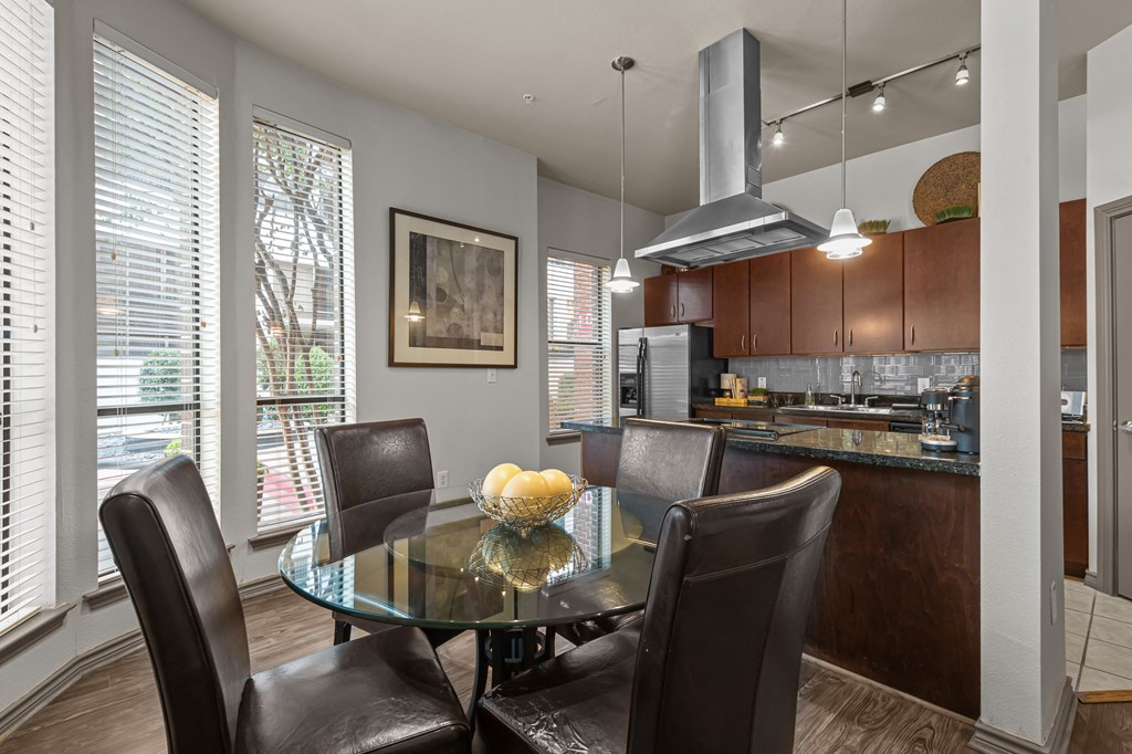a kitchen and dining room with a glass table and chairs