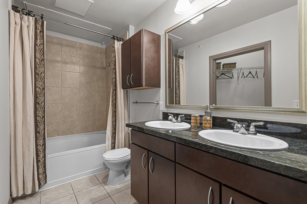 a bathroom with two sinks and a shower and a toilet