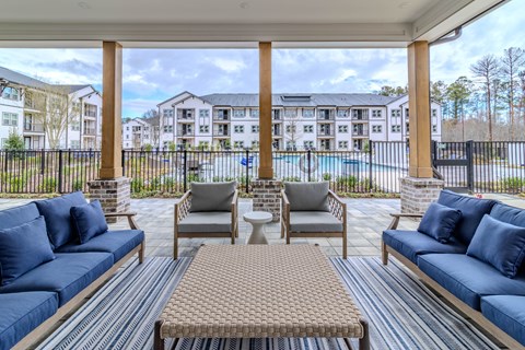 A patio with a pool and apartment buildings in the background.