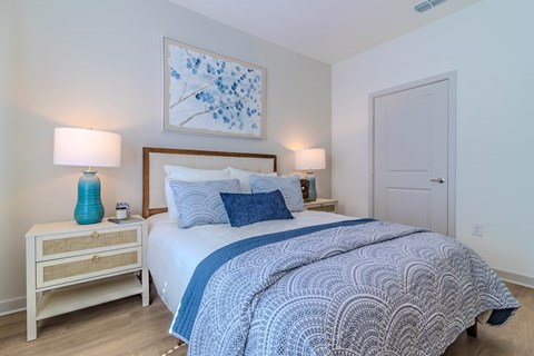 A bedroom with a bed, nightstand, and two lamps.