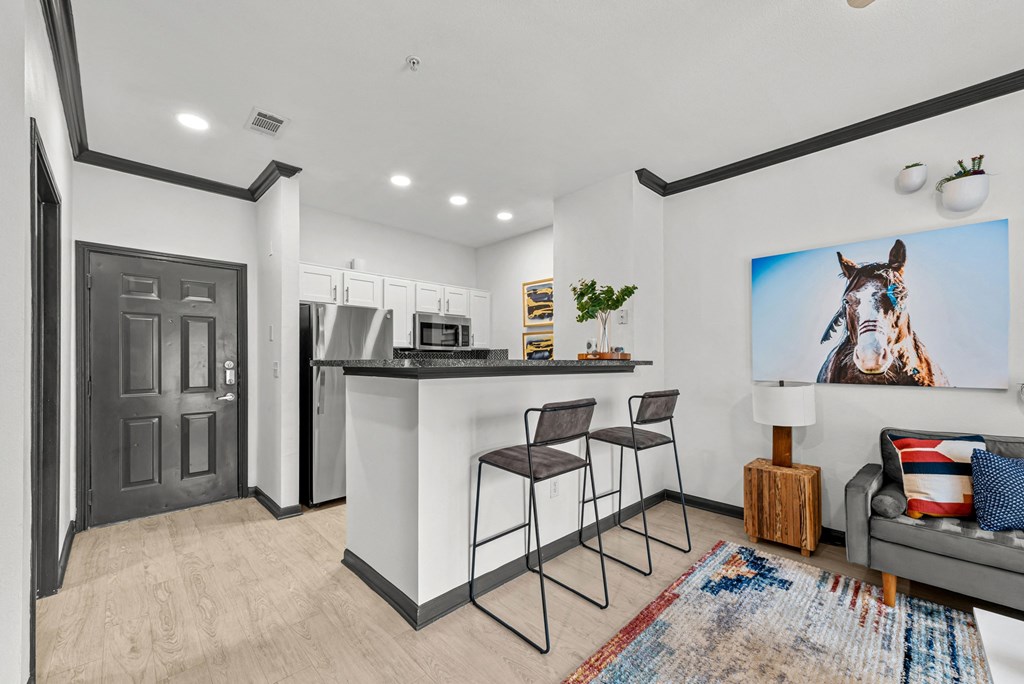 A modern kitchen with a bar area and a large painting of a horse on the wall.