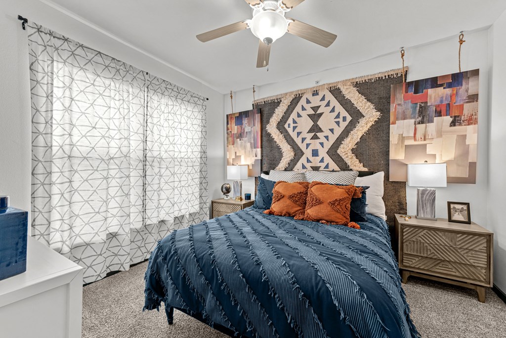 A bedroom with a large bed and a ceiling fan.