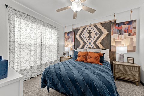 A bedroom with a large bed and a ceiling fan.