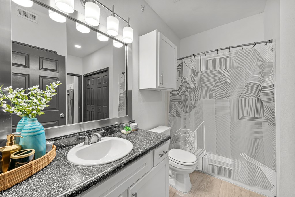 A bathroom with a white sink and a white toilet.