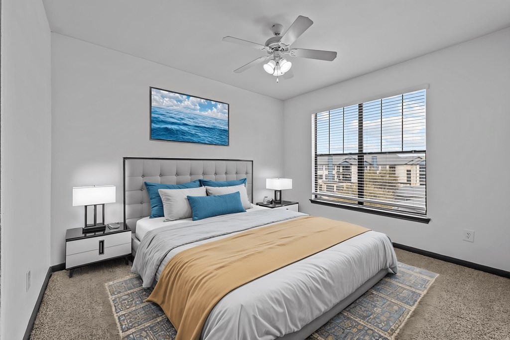 A bedroom with a large bed and a ceiling fan.