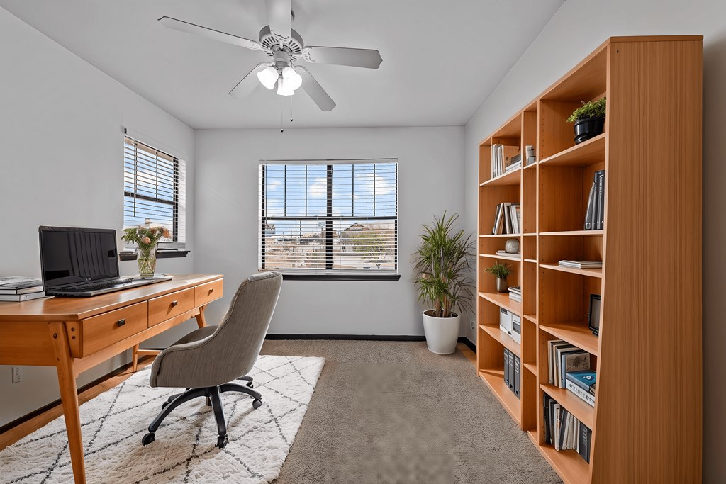 A room with a desk, chair, and bookshelf.