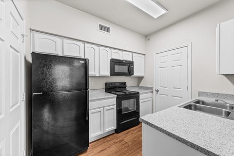 the preserve at ballantyne commons apartment kitchen with black appliances and white cabinets
