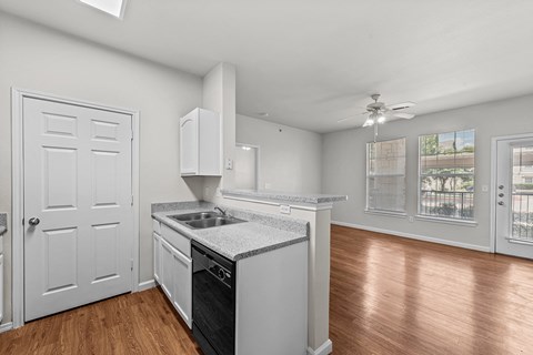 a kitchen with an island and a door to a living room