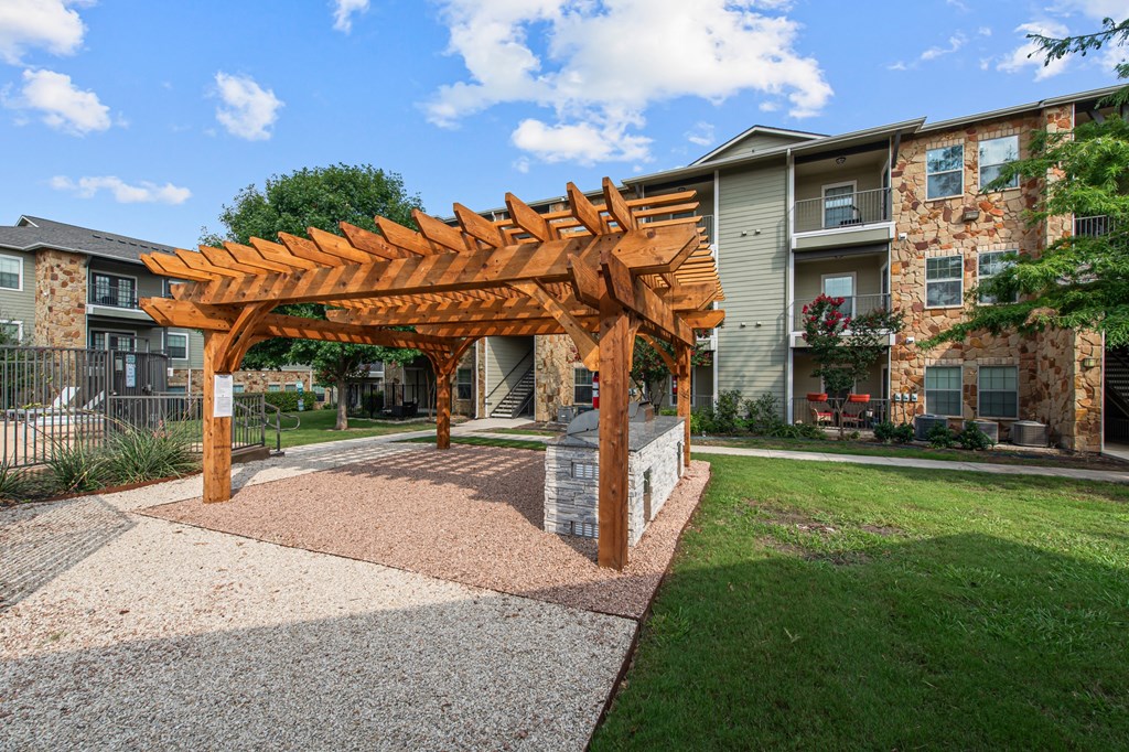 a wooden pergola in front of an apartment building
