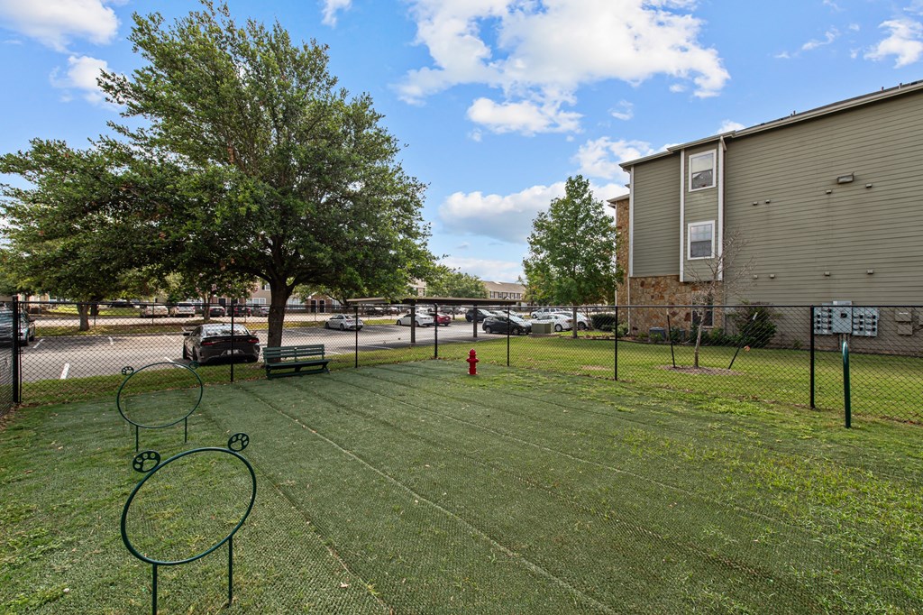 the yard is fenced in with a tennis court and tennis rackets