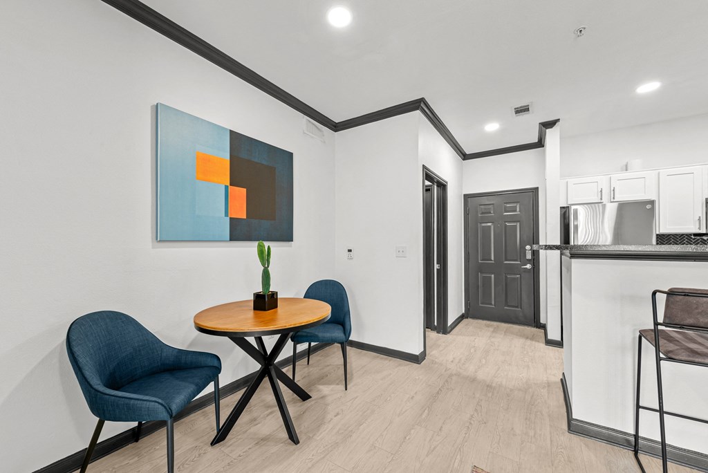 A modern dining area with a round table and chairs.