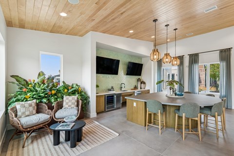 A modern kitchen with a wooden ceiling and a dining table set with chairs.