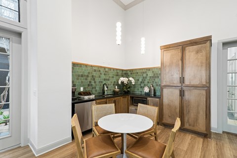 A kitchen with a table and chairs.
