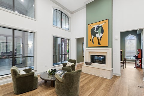 A living room with a fireplace and a painting of a cow on the wall.