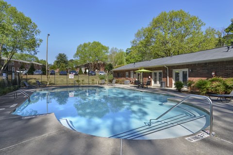 a swimming pool with a house and trees in the background