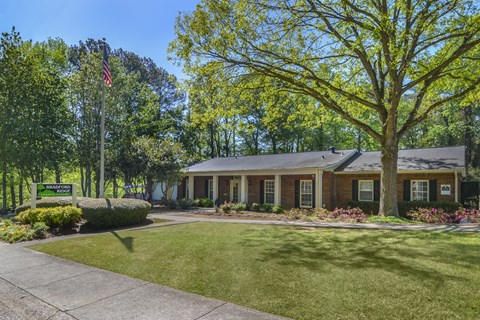 the front of a house with a lawn and trees