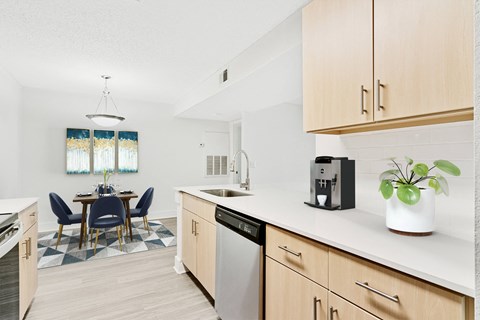 A kitchen with a dining table and chairs.