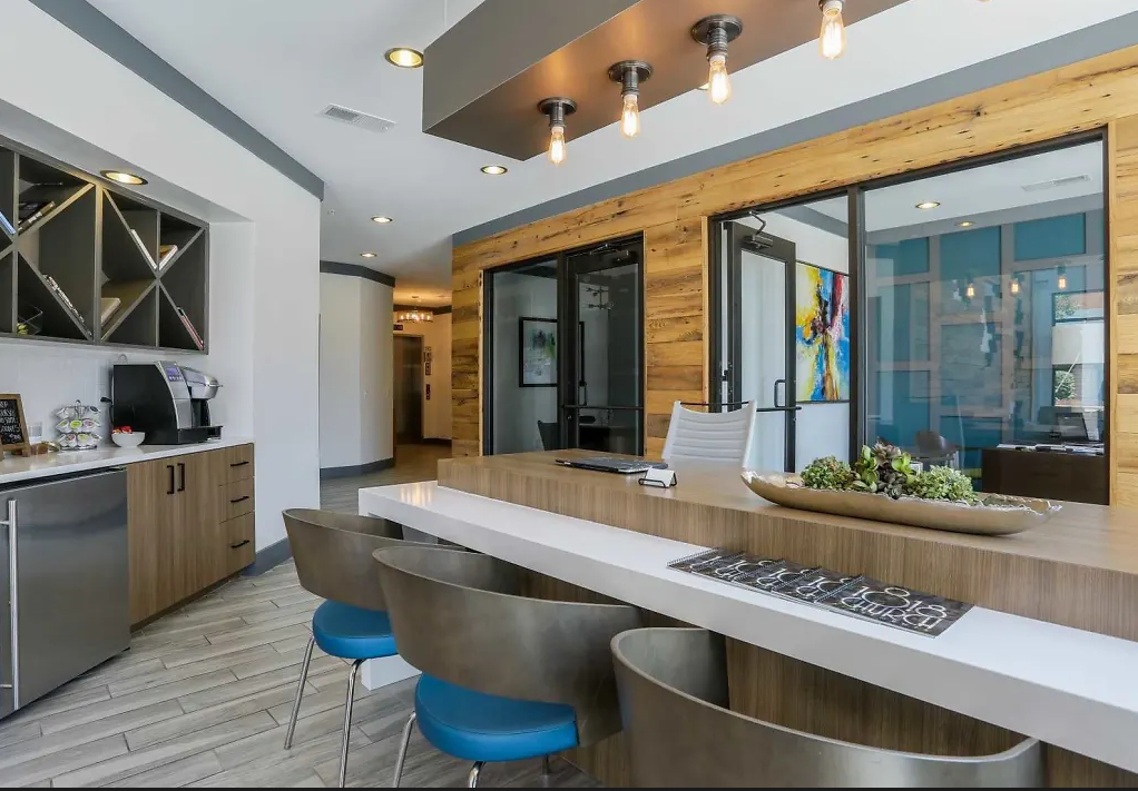 a kitchen with a long counter and blue chairs