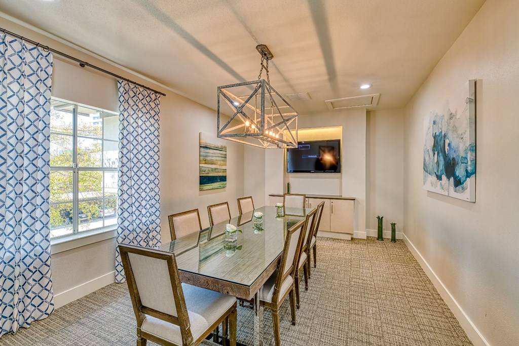 a dining room with a long table and chairs and a large window