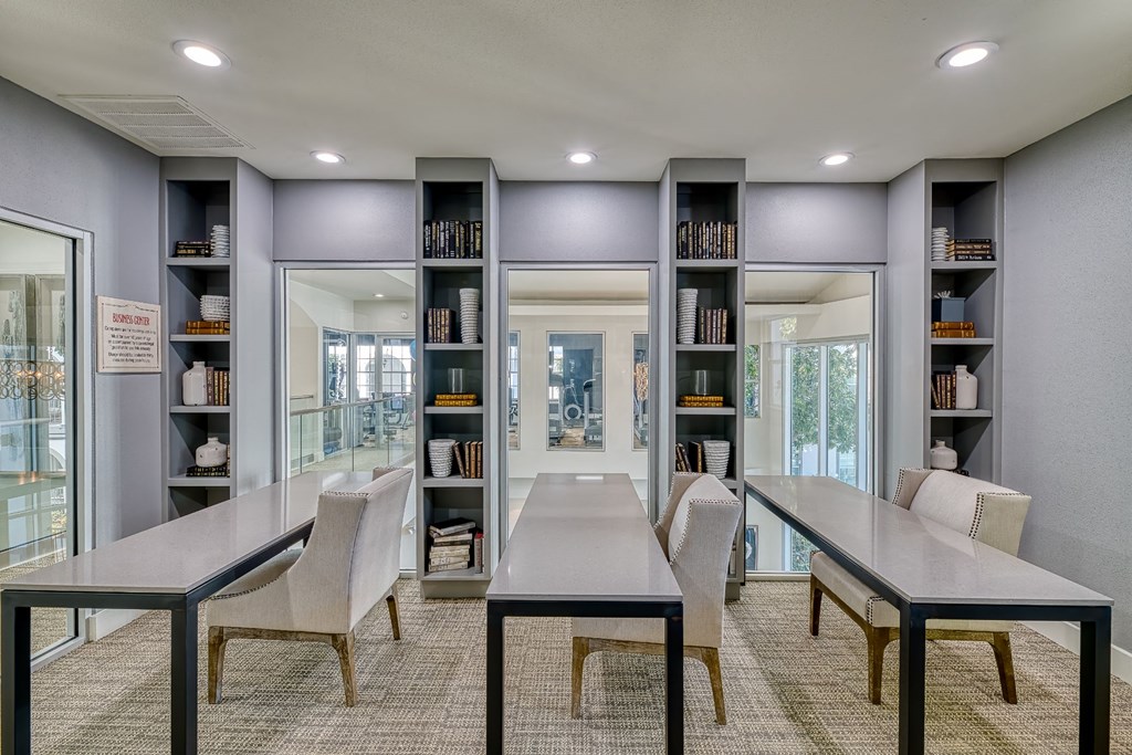a conference room with two tables and chairs and a library