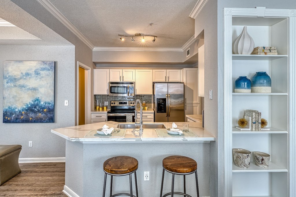 an open kitchen with a bar and stools