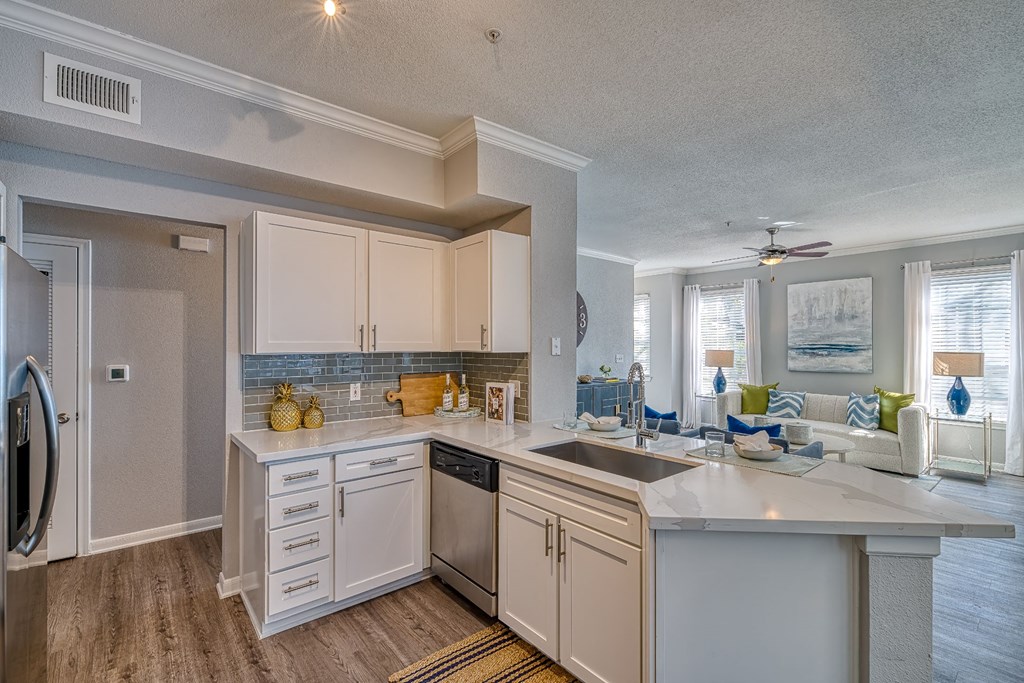 a kitchen with white cabinets and a large counter top