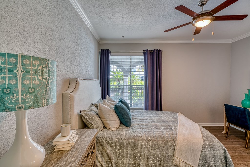 a bedroom with a large bed and a ceiling fan