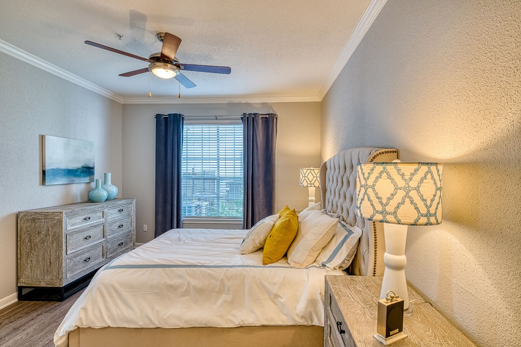a bedroom with a large bed and a ceiling fan