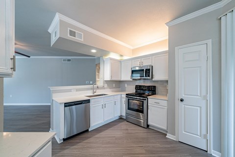 A kitchen with white cabinets and stainless steel appliances.