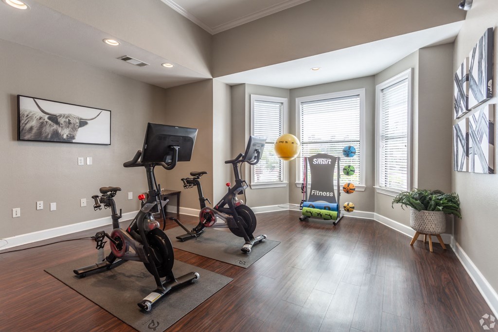 a home gym with exercise equipment and windows