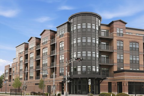 A modern multi-story building with a curved design and large windows.
