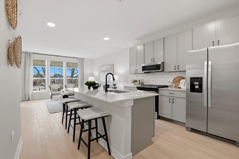 A kitchen with a large island and stools.