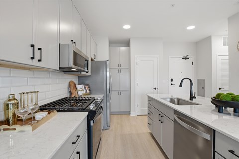 A modern kitchen with a stove top oven and a refrigerator.
