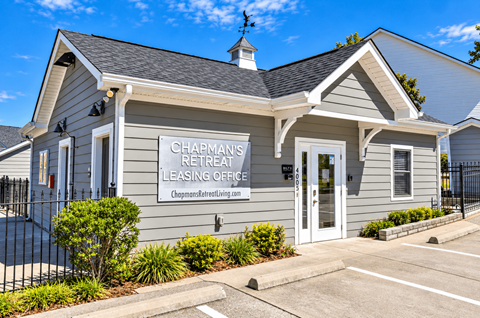 A Chapman's Retreat leasing office with a parking lot in front.